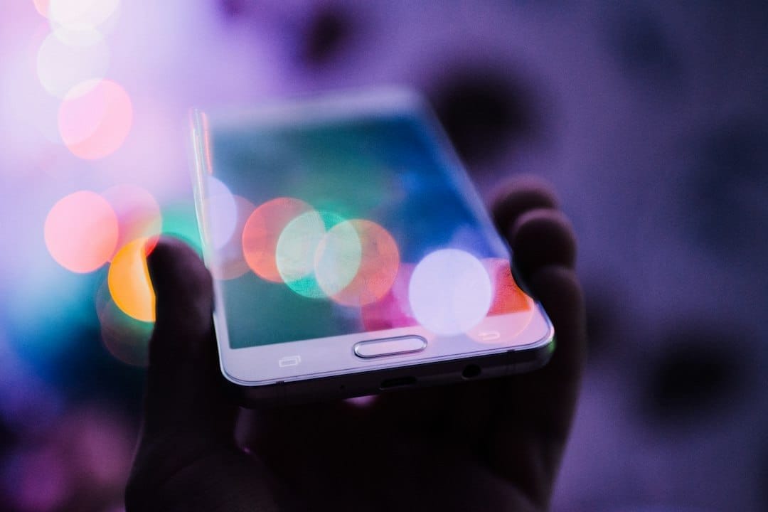 Mightyoak UK - Web Design Cornwall - A person holding up a smartphone with bokeh lights.